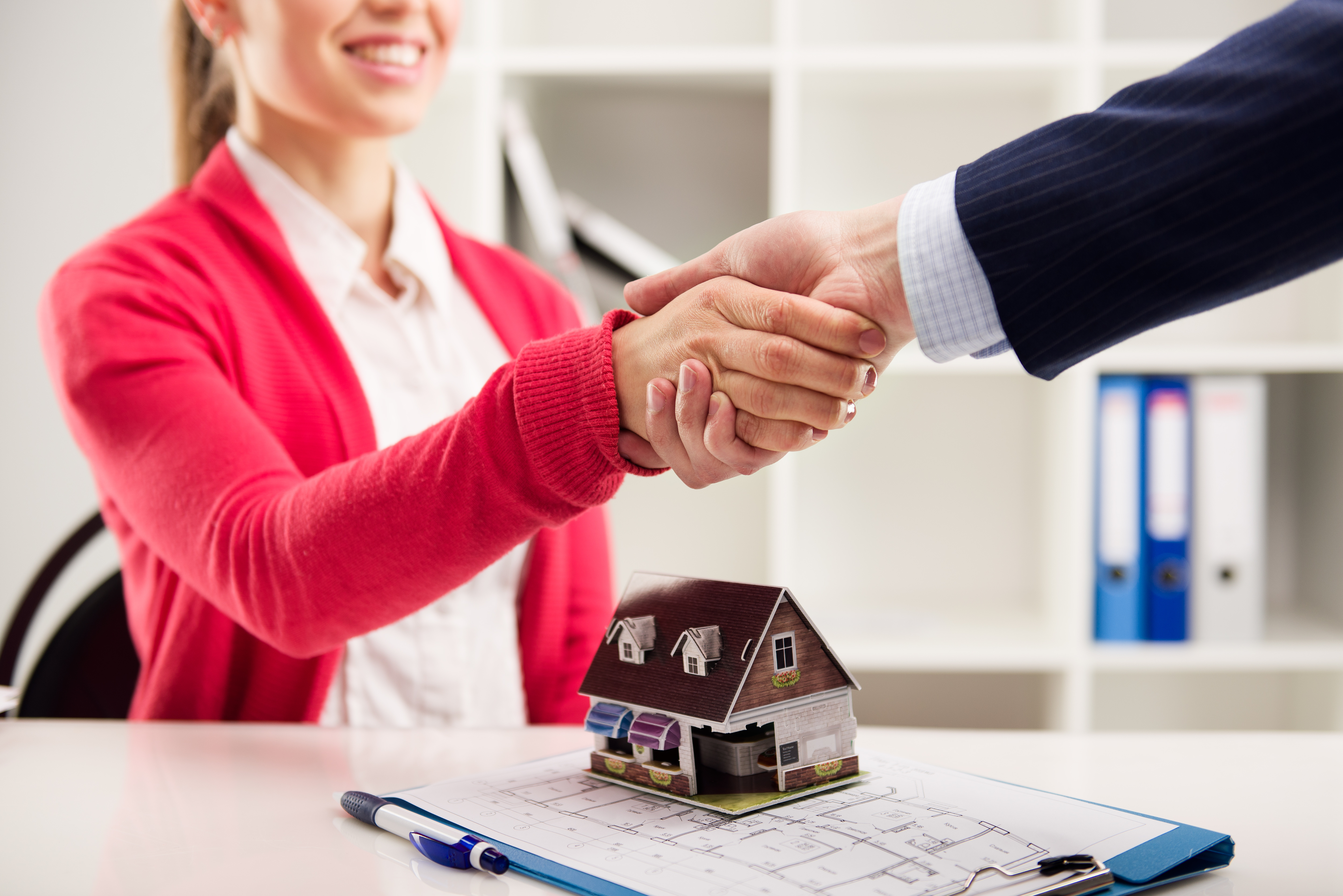 Business partnership. House agent greeting customer in office